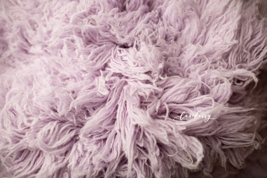 Close-up of a fluffy, light purple wool flokati